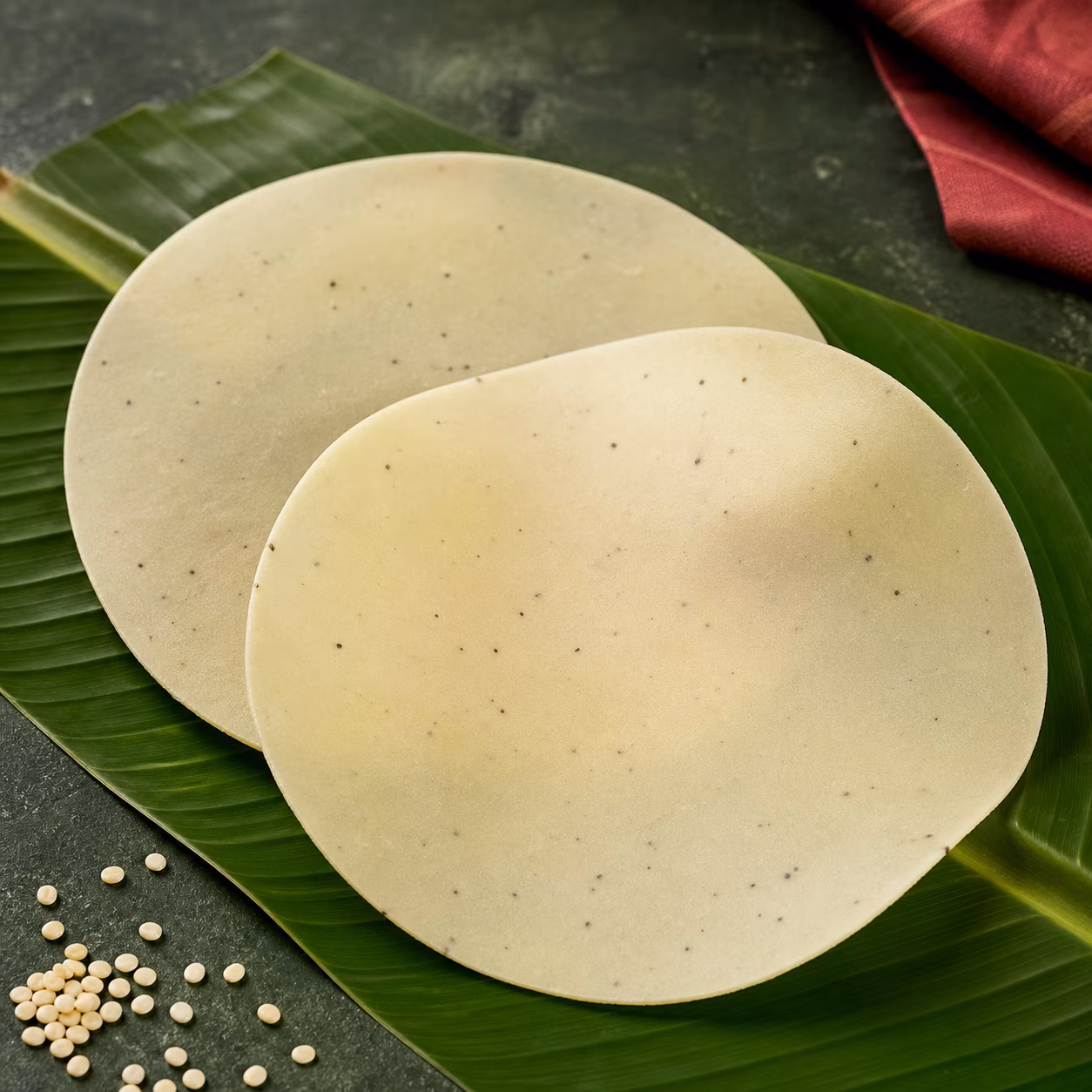 Uncooked Kerala pappadam arranged on a fresh banana leaf